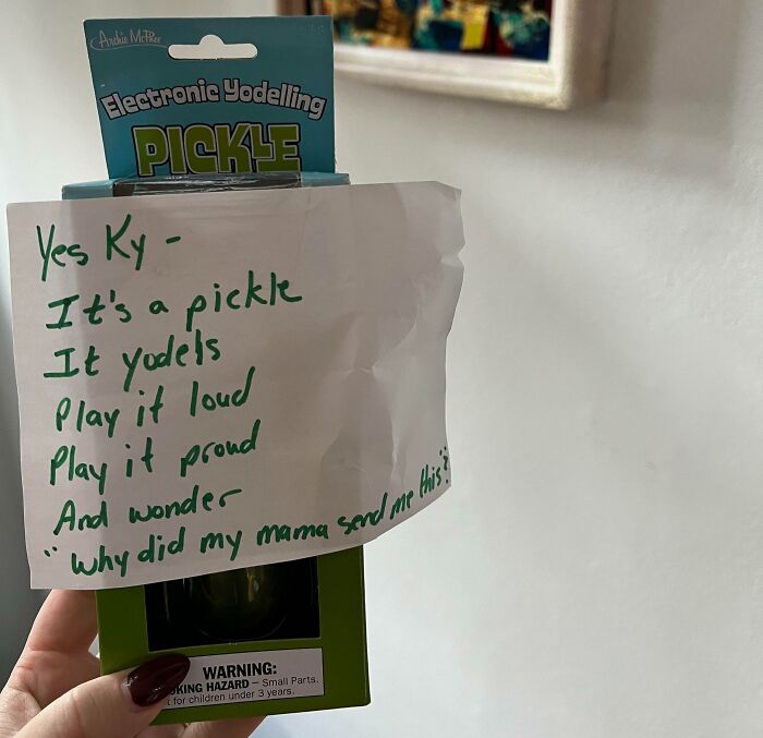 Handwritten creative and amusing note left by a parent attached to an electronic yodeling pickle toy.