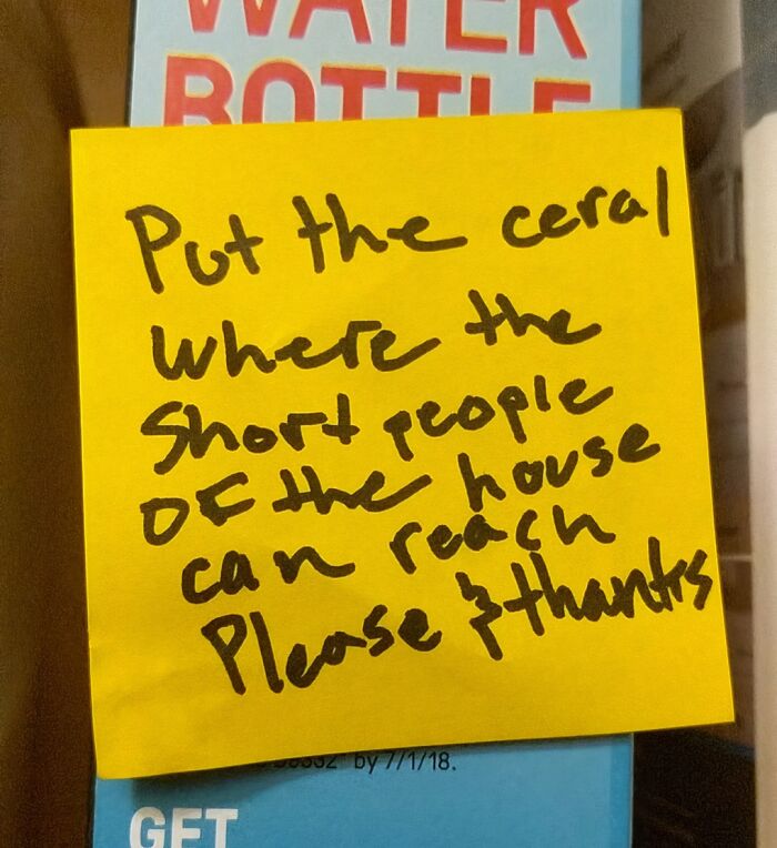 Yellow sticky note with a creative and amusing note left by a parent about placing cereal within reach of short people.