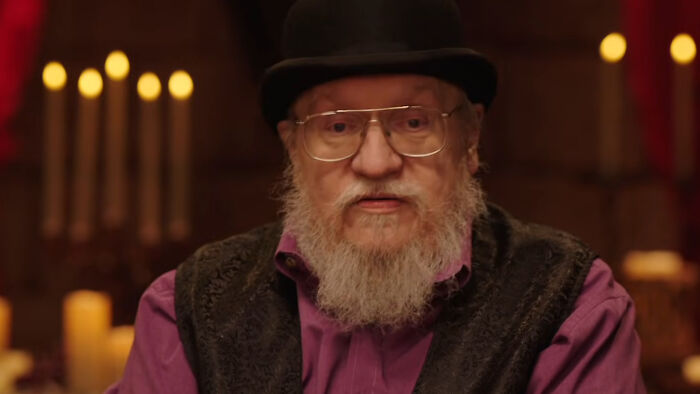 An older man with a white beard and glasses wearing a black hat and vest discussing a Knight of the Seven Kingdoms update. An older man with a white beard and glasses wearing a black hat and vest discussing a Knight of the Seven Kingdoms update.