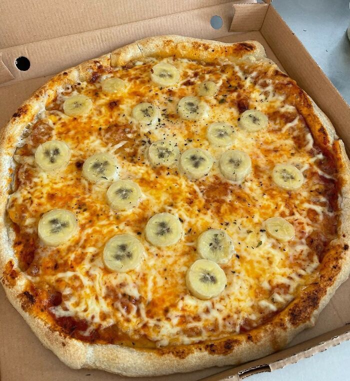 Pizza topped with banana slices, showing a food combination normal in some countries but offensive elsewhere.
