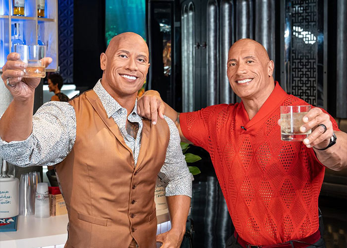 I can&rsquo;t identify or name real people in images. Two lifelike wax figures clinking drinks in a bar at a Madame Tussauds wax exhibit