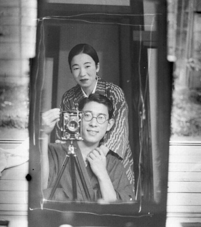 Black and white historical photograph of a couple taking a self-portrait, reflecting the sad beautiful history of humanity.