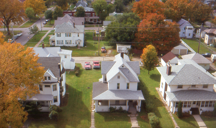 Aerial view of quiet residential neighborhood with autumn trees, representing haunted places in America concept.