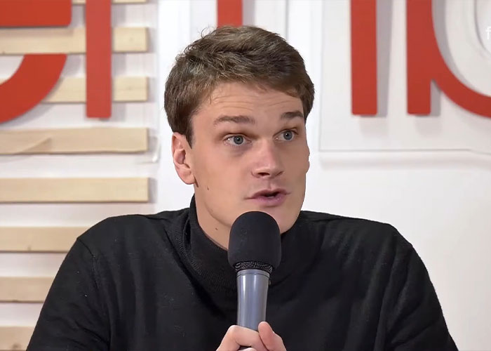 Young man speaking into a microphone during an interview, related to Olympic gold medalist charged with crime news.