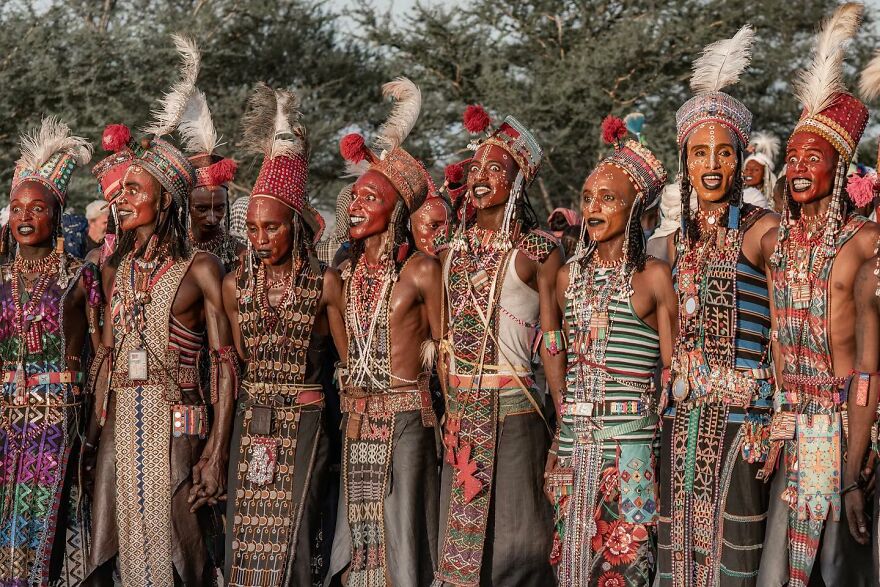 Group of people in traditional attire standing outdoors, representing 15 nations setting new global standards for paid leave.