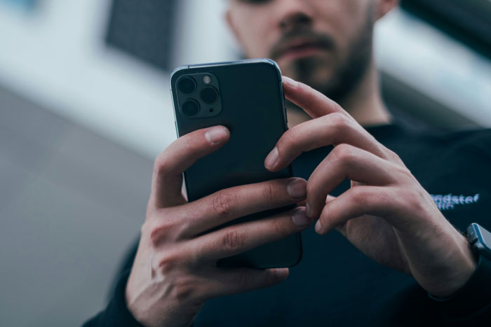 Man focused on his phone screen, highlighting the role of phone clues in cheating revelations.
