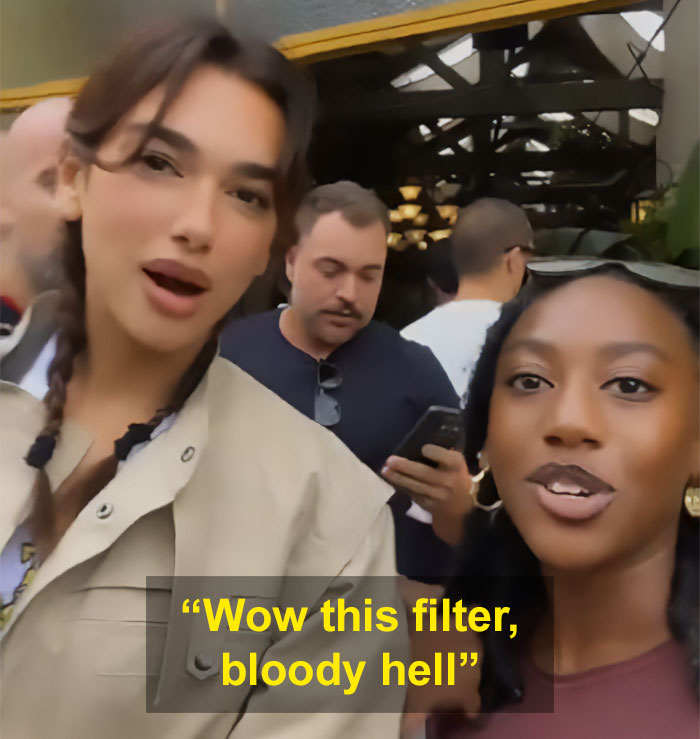 Dua Lipa reacting to South African fan using a filter on their selfie with her at a crowded indoor location.