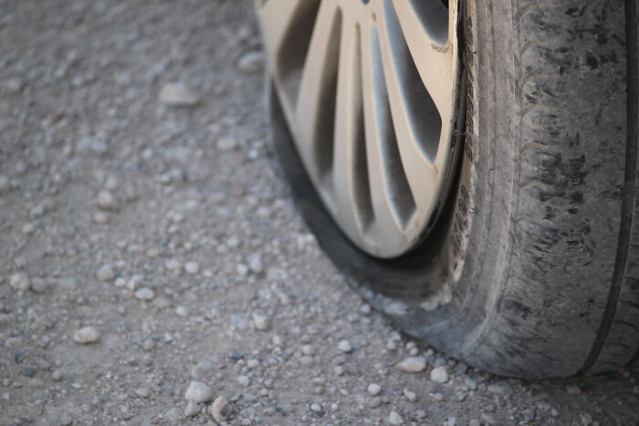 Flat car tire on gravel road, illustrating moments people were surprised or creeped out by intelligence.