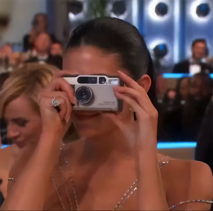 Celebrity at Golden Globes using a camera, highlighting after Timoth&eacute;e Chalamet snubs Kylie Jenner event moments.