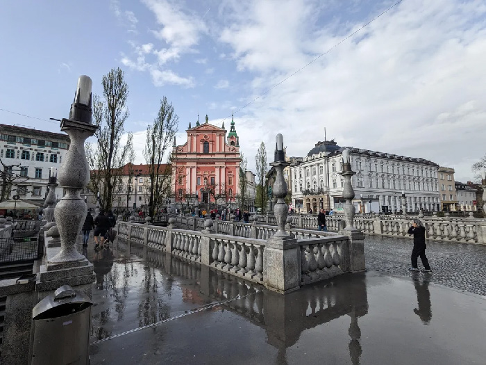 Scenic city square with historic buildings and people walking, illustrating one of the best countries to raise a family.