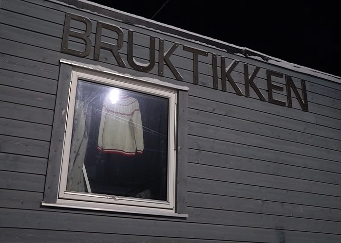 Exterior of a gray building with a window showing a sweater, highlighting life on the world&rsquo;s darkest island.