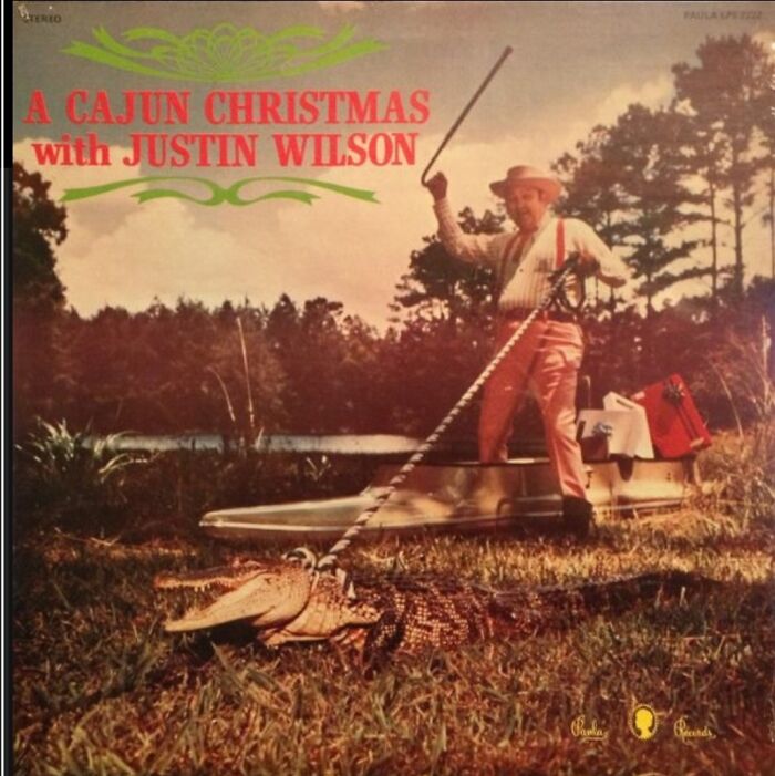 Vintage Cajun Christmas album cover featuring a man in suspenders with a large alligator by a boat in a swamp setting.