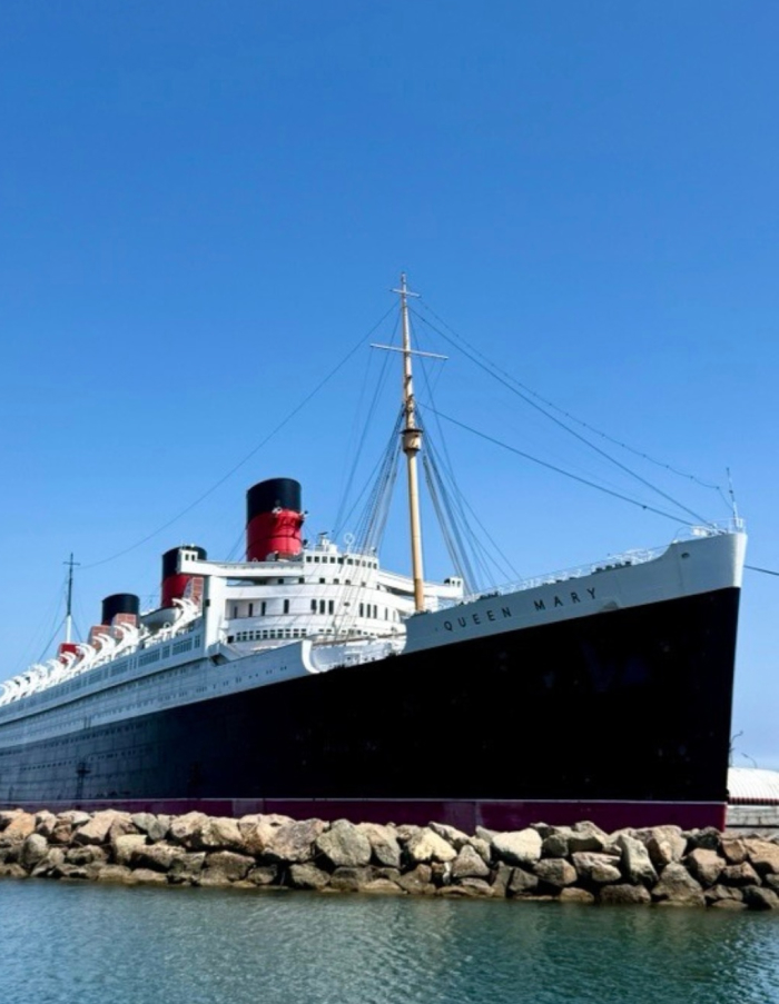 Queen Mary ship docked under clear blue sky, known as one of the most haunted places in America.