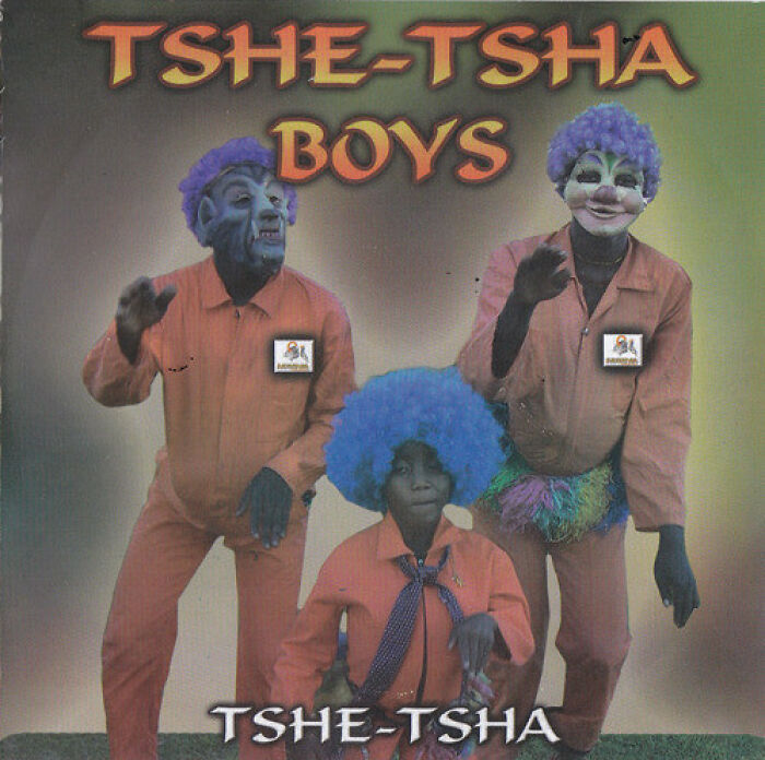 Album cover showing three people in blueface and wigs wearing orange outfits, a hilariously bad album cover sold publicly.