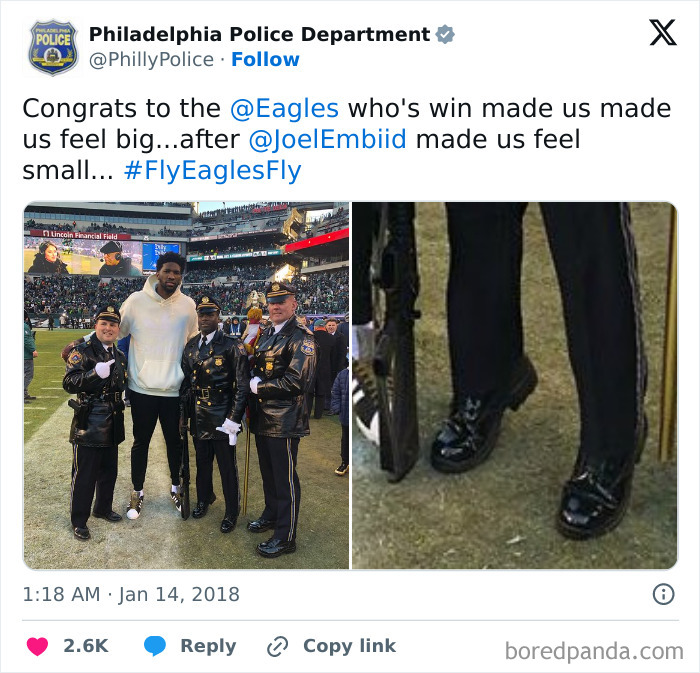 Philadelphia police officers posing with a basketball player on a football field in a lighthearted social media post.