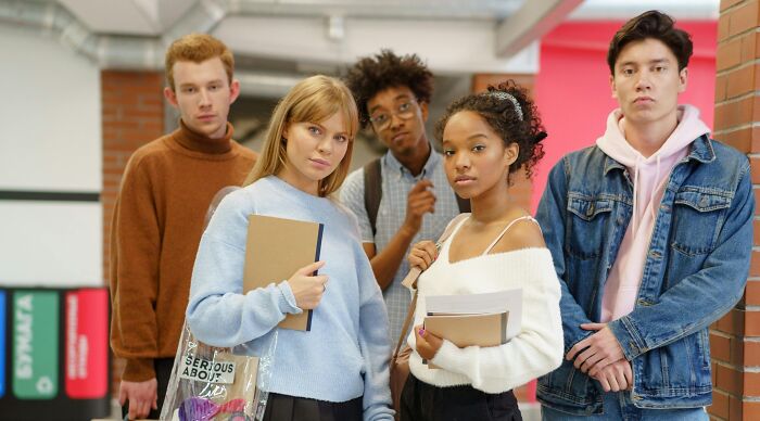 Group of diverse high school students holding books, appearing confident ready to take a challenging 9th-grade exam test.