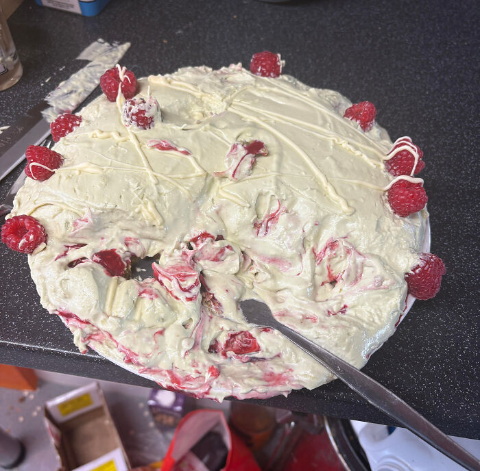 Messy dessert with smashed raspberries and uneven cream spread, an example of people ruining dessert unexpectedly.