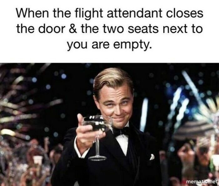 Man in tuxedo raising a glass in celebration, illustrating travel meme about empty seats on a flight.
