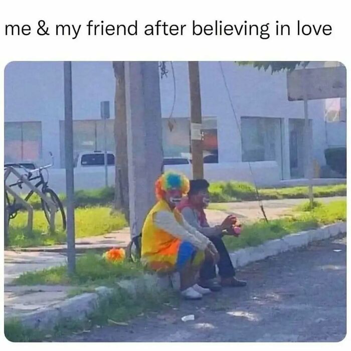 Two people in clown costumes sitting on a sidewalk, illustrating relatable memes about life as an introvert.