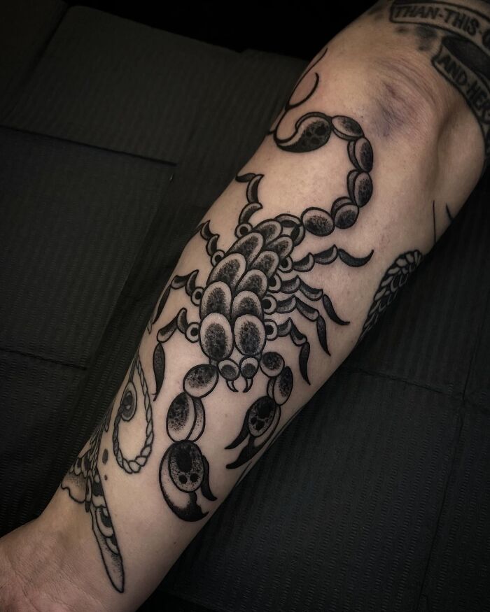 Black and grey scorpion tattoo on forearm showcasing cool tattoos that look almost unreal in detail and shading.