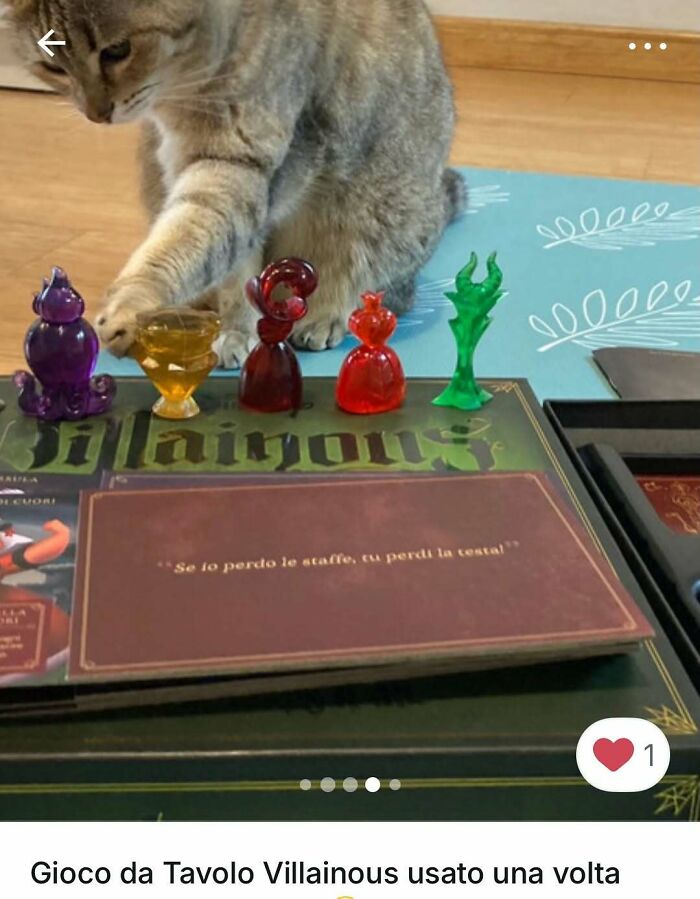Cat paw reaches for colorful game pieces on a board in a playful moment featuring cats in Vinted ads.