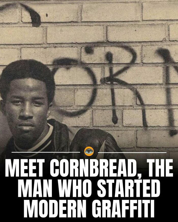 Young man posing in front of a brick wall with graffiti, highlighting lighthearted facts and pics about modern graffiti.
