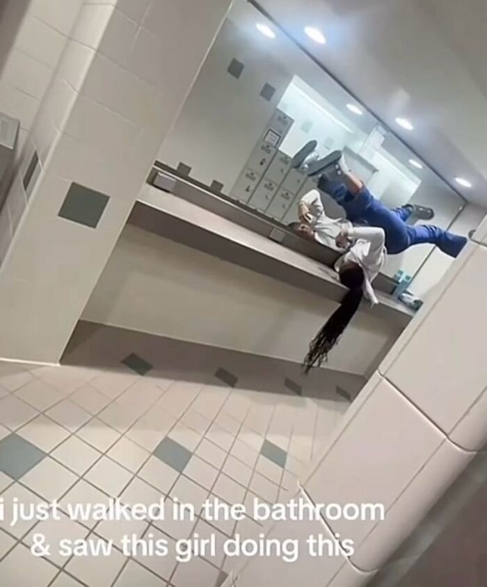 Girl balancing upside down on bathroom counter in a bizarre and random meme that might leave you with more questions than answers