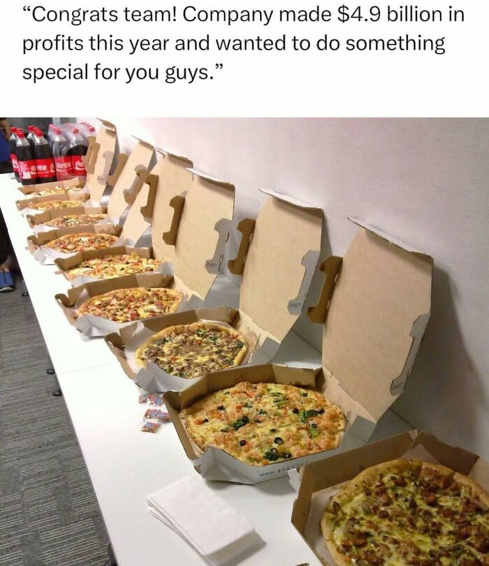 A row of open pizza boxes on a table with soda bottles, illustrating a funny meme about company profits and team rewards.