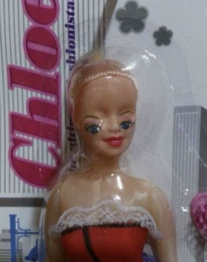 Close-up of a bizarre doll with distorted eyes in packaging, illustrating a random and strange meme concept.
