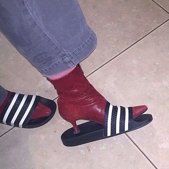 Person wearing red high heel socks with black and white slide sandals on tiled floor, a random and bizarre meme.