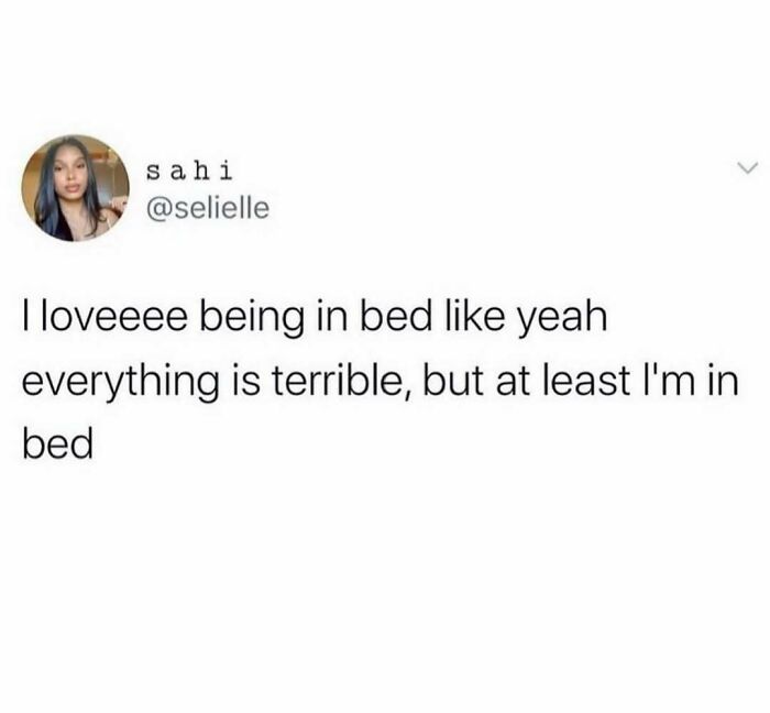 Funny meme text about loving being in bed despite everything feeling terrible, for distraction and humor purposes.