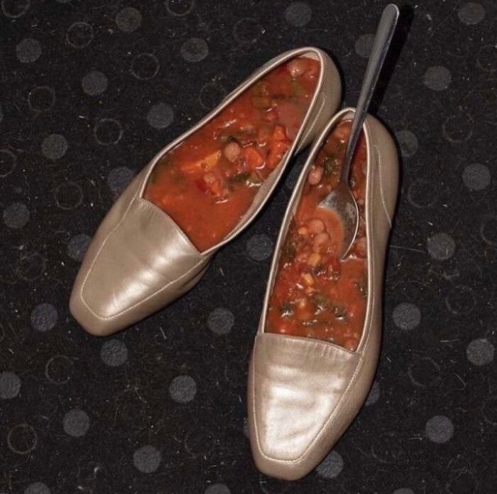 A pair of beige shoes filled with chunky vegetable soup and a spoon, creating a bizarre and random meme image.