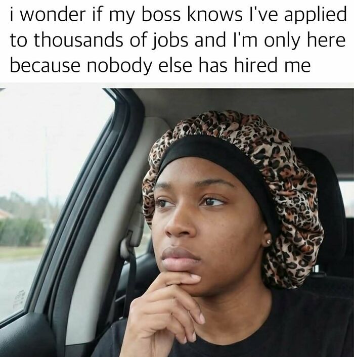Young woman with a leopard print bonnet looking thoughtful in a car, a funny meme to distract from work stress and job worries