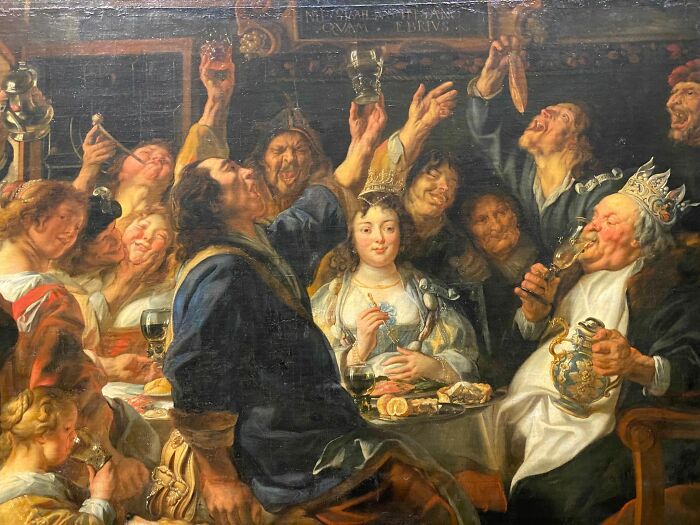 Old painting of a lively medieval feast with exaggerated expressions, showcasing hilariously bad art style and vibrant characters.