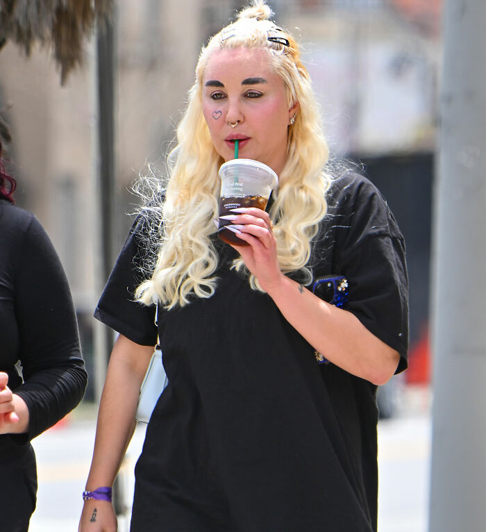 Amanda Bynes walking outside with a new tattoo, sipping iced coffee, raising fans' concern over a possible scream for help.