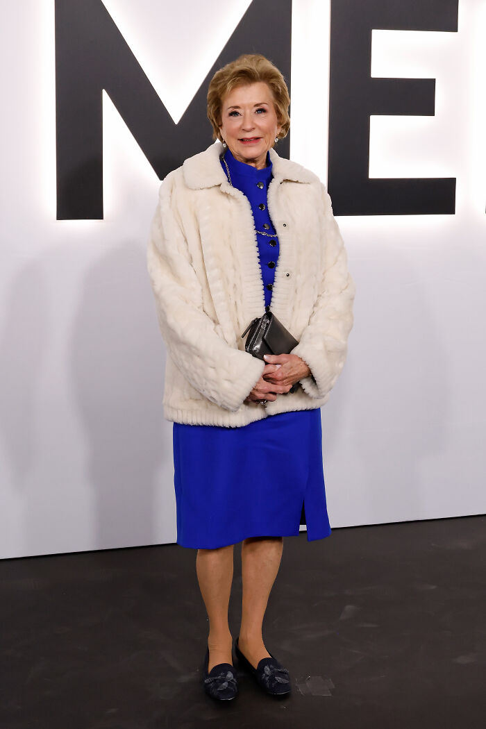 Elderly woman wearing a white fur coat and blue dress at an event highlighting worst MAGA looks.