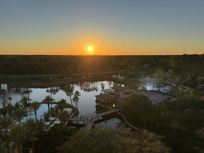 Sunset over a peaceful Central Florida resort with calm waters, palm trees, and serene natural beauty.