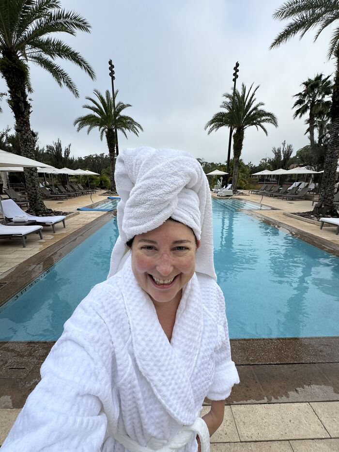 Woman in a white robe and towel by a peaceful pool in Central Florida, experiencing silence, beauty, and real emotion.