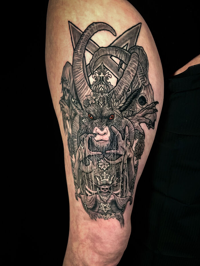 Intricate tattoo on thigh featuring a horned creature and dark, detailed elements, showcasing cool tattoo art.