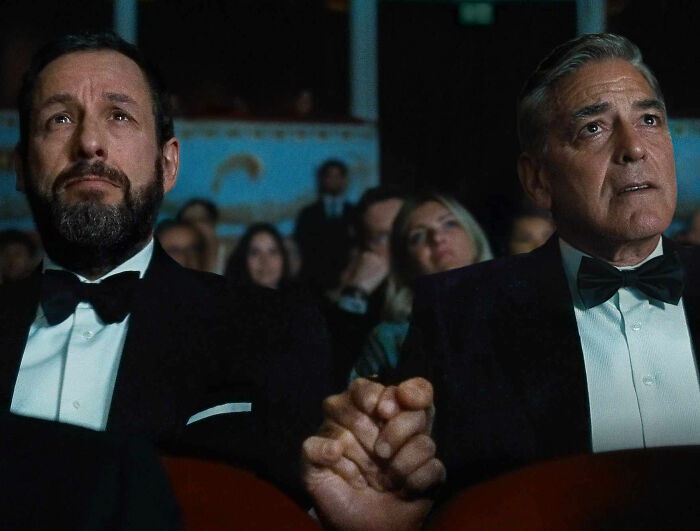 Two men in tuxedos holding hands in a theater audience during the Academy releases 2026 Oscar nominations event. Two men in tuxedos holding hands in a theater audience during the Academy releases 2026 Oscar nominations event.