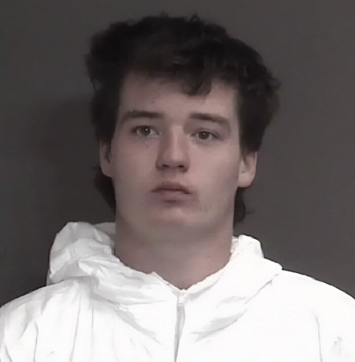 Young man in a white jacket looking ahead in a mugshot related to Marine veteran's heartbreaking final text case.