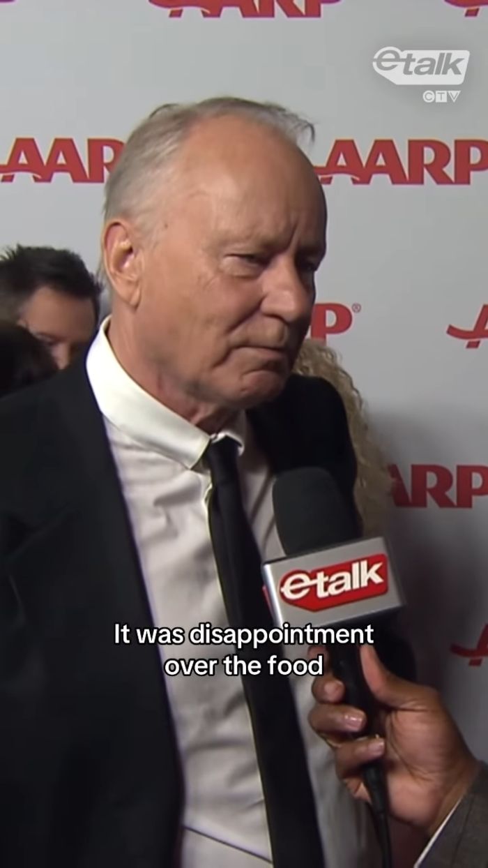 Stellan Skarsg&aring;rd speaking about Critics Choice Awards disappointing food during an interview in formal attire.