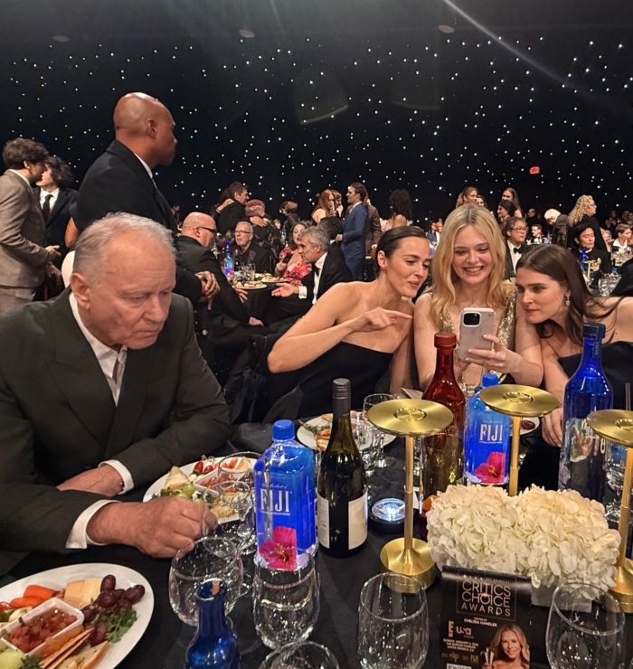 Stellan Skarsg&aring;rd seated at Critics Choice Awards table with food and guests during the event.