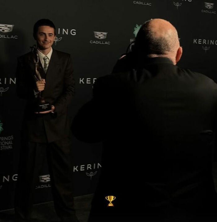 Timothée Chalamet holding an award at an event while a photographer captures the moment, fans note sad detail. Timothée Chalamet holding an award at an event while a photographer captures the moment, fans note sad detail.