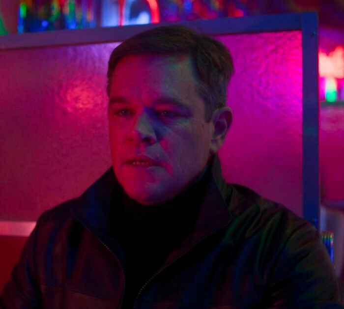 Matt Damon in moody lighting, wearing a black jacket, reflecting on cancel culture amid the Amanda Knox feud.