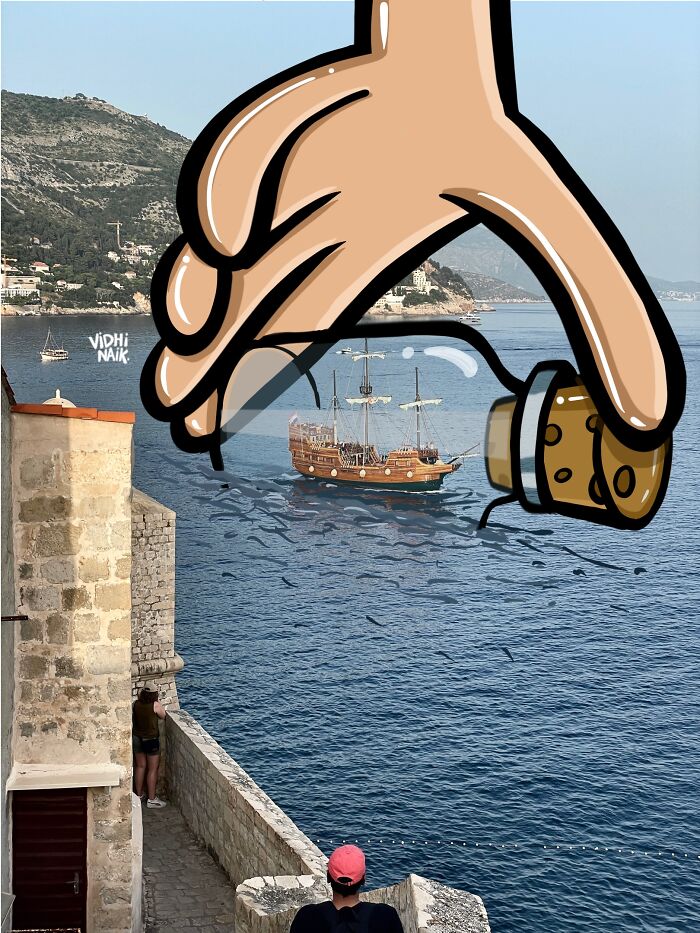 Cartoon hand holding a ship in a bottle over a coastal scene, blending everyday places with cartoon scenes by artist Vidhi Naik.