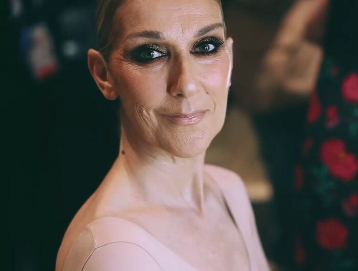 Close-up of a woman with dramatic eye makeup and a soft smile, representing celebrities who faced undeserved downfall.