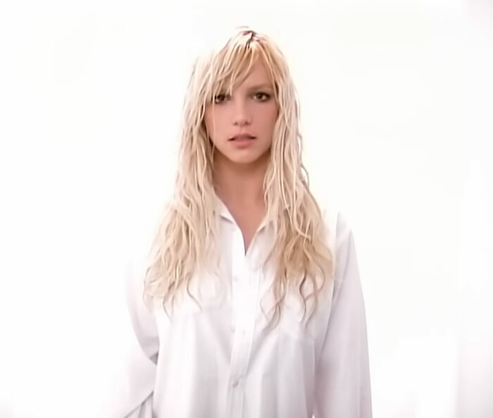 Blonde woman with long wavy hair wearing a white shirt, representing celebrities who faced an undeserved downfall.