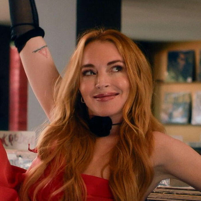 Actress with long red hair smiling and posing indoors, representing celebrity downfalls that evoke sympathy.