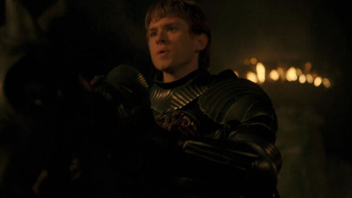 Actor in a dark armored costume portraying a Targaryen character from A Knight Of The Seven Kingdoms series.